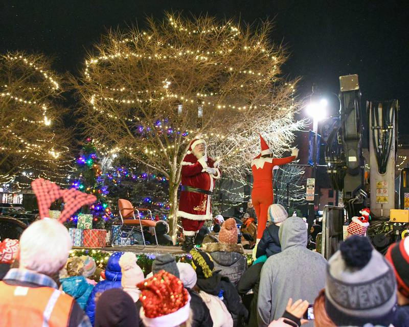 Community members gather around Santa Claus and one of his elves as they stop in front of the Egyptian Theatre during the DeKalb Chamber of Commerce's annual Lights on Lincoln and Santa Comes to Town event held in downtown DeKalb on Thursday, Nov. 30, 2023.