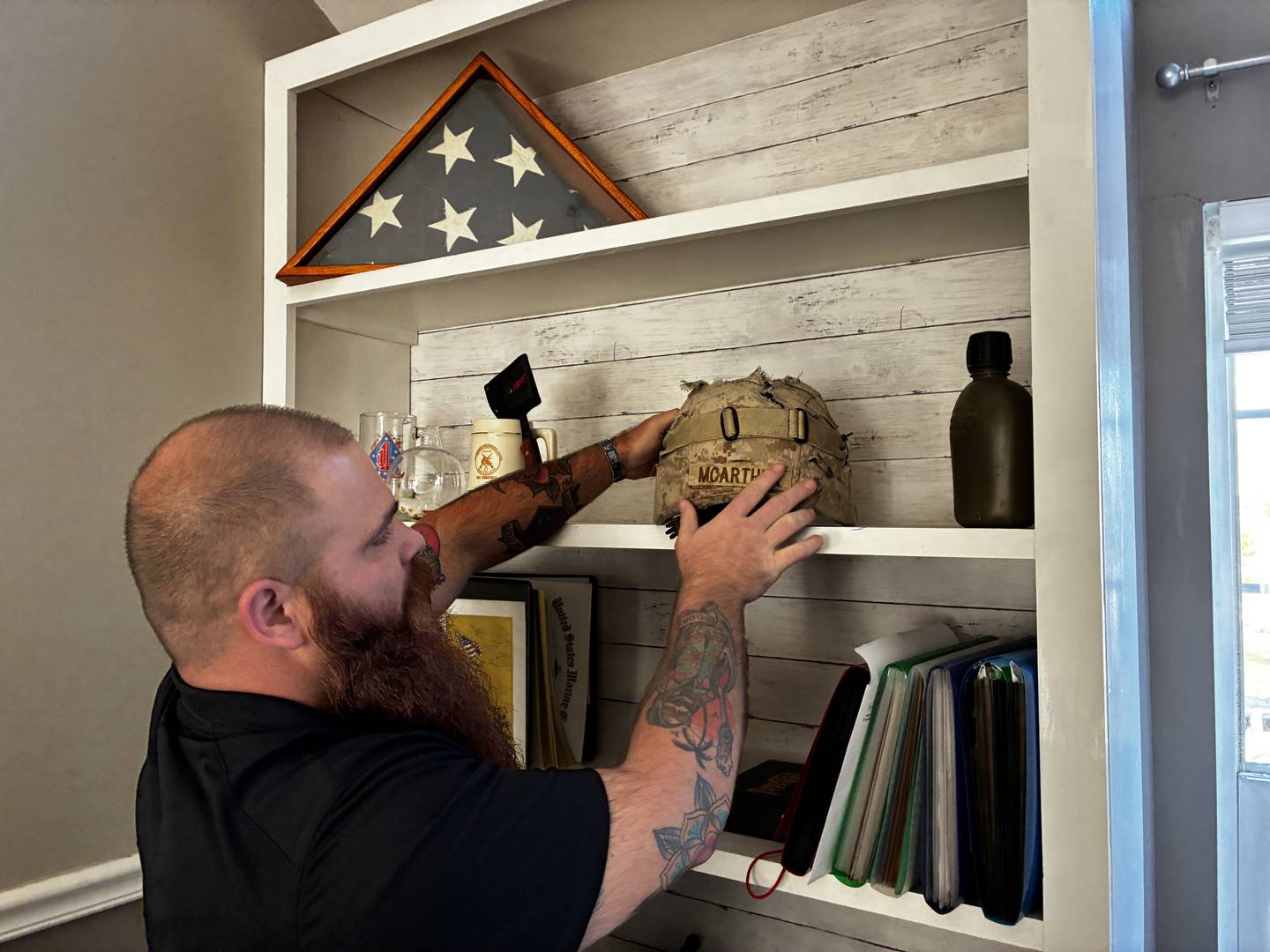U.S. Marine Corps veteran Luke McArthur displays the helmet that saved his life in Afghanistan in 2012. He is one of 30 McHenry County veterans who will get projects taken care of at their homes via the 30 Days for 30 Vets program.