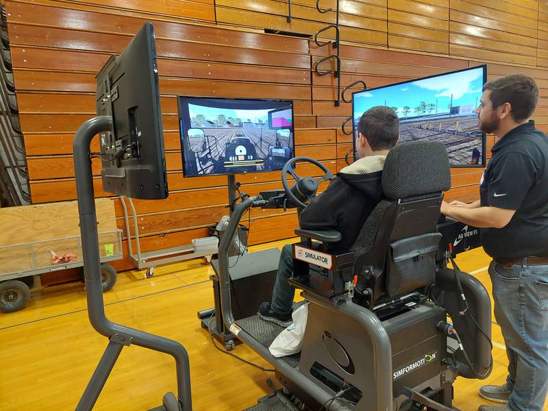 David Cotter of Ag View FS watches as students try out the field sprayer simulator Friday, April 19, 2024, at the Career, Job and Volunteer Fair at Princeton High School. Cotter said the simulator is used for training operators.