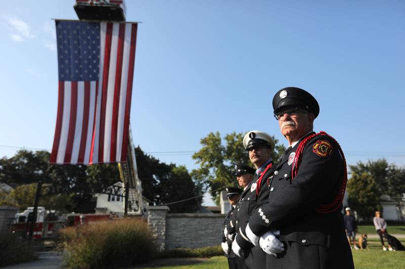 Retired McHenry Township Fire Protection District firefighter Guy Smale with other firefighters listens to McHenry Mayor Wayne Jett speak during a September 11 Remembrance Ceremony on Sept. 11, 2025, at Veterans Park in McHenry.