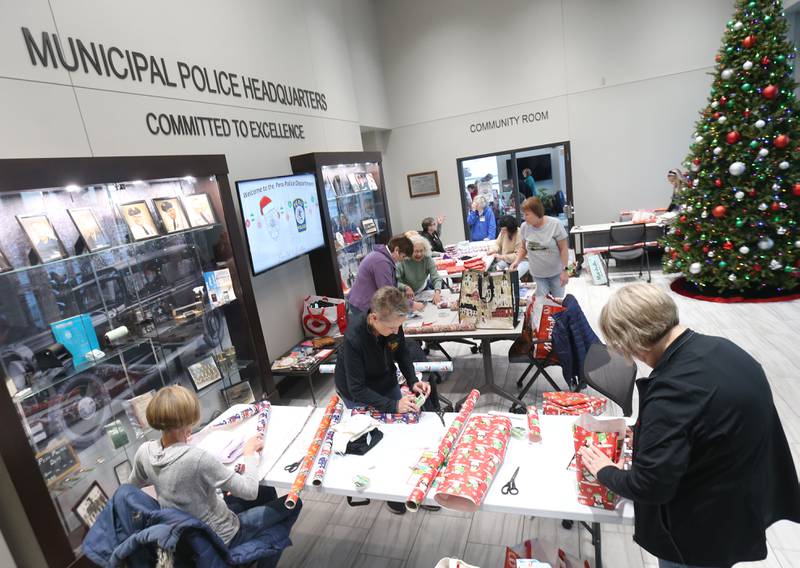 Members of the La Salle-Peru Township High School Class of 1975 wrap presents for the Blue and Red Christmas for Kids on Tuesday, Dec. 16, 2025 at the City of Peru Public Safety Complex. Blue and Red will be delivering gifts to 85 children on Friday, Dec. 19. Area schools provided toys to fire and police departments with children's names and their Christmas lists. The program relays on donations including a $2,000 donation from the City of Peru in November. The Christmas program was established in 2013 by the Peru police and fire departments. It donates more than gifts to children in need; it provides personalized gifts for each child and family, including clothing and toys.