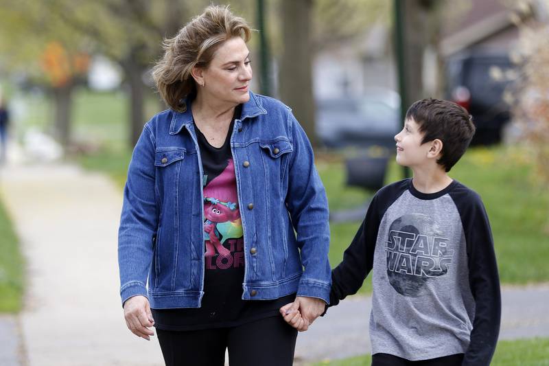 Chris Chirchirillo takes a walk with Jaxen Esparza, 8, down to the little free library at the end of her block on Saturday, April 24, 2021 in Lake in the Hills. Chirchirillo is one of 24 people to receive an outpatient robotic lung surgery at Northwestern Medicine and, four months later, is enjoying returning to normal activities.