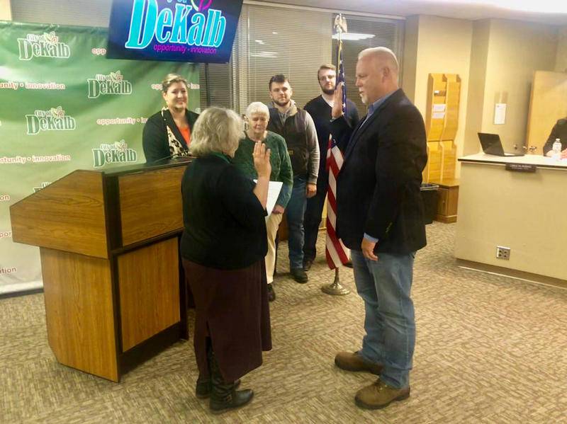 City Clerk Lynn Fazekas (left) swears in Gregory Perkins (right) as DeKalb's new 4th Ward alderman Tuesday as his family looks on.