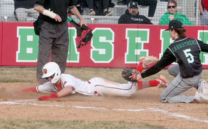 L-P's Seth Adams slides safely into home plate on a pass ball as Alleman pitcher misses the tag on Tuesday, March 12, 2024 at the L-P Athletic Complex in La Salle.