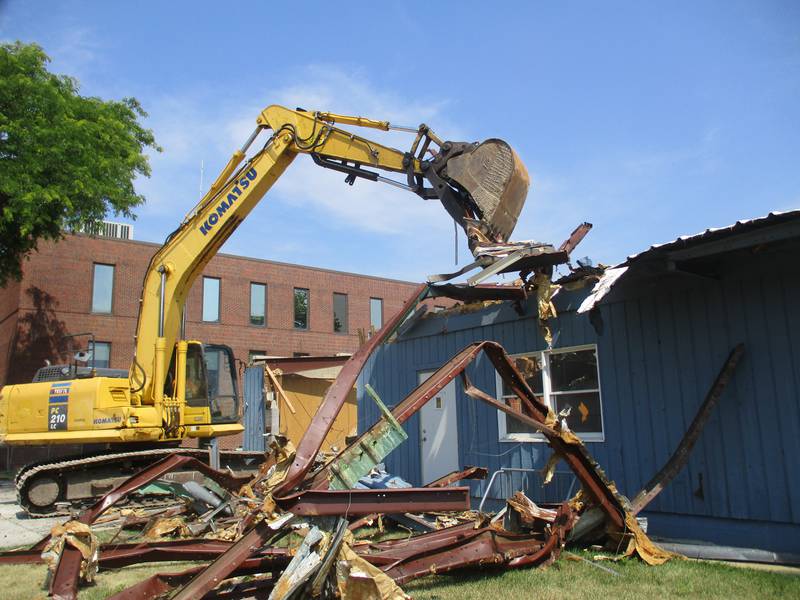 A demolition claw rips apart the county annex building in downtown Yorkville to make way for expansion of the Kendall County office campus on June 22, 2023. Looming in the background is the three-story Kendall County Office Building, home to the county administration.