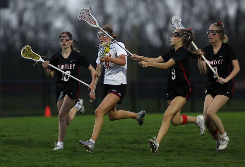 Crystal Lake Central co-op's Isabella Jackson second from (left) tries to control the ball between Huntley's Aubrie Salazar, (from left to right) Huntley's Isabella Gregorio, and Lauren Cardinal during a Fox Valley Conference girls lacrosse match on Friday, April 17, 2026, at Crystal Lake Central High School.