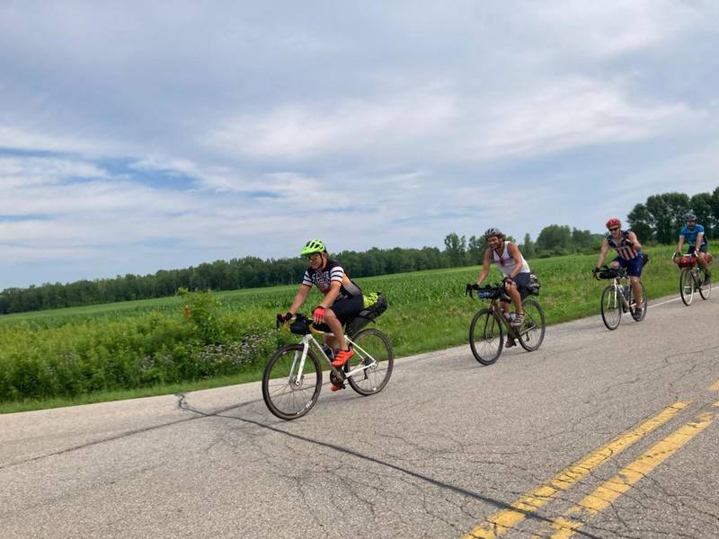 (From left to right): Kane County residents Jason Schoenfelder, Jon Burmeister, Brian Scott and Cavin McKinley bike on a road. The group went on a 10-day biking adventure around Lake Michigan. Nick Jett and Dan Craychee started the journey, dropped out on day two and met up with the group on the other side of the lake.