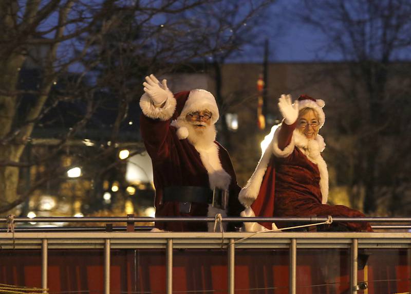 Santa and Mrs. Claus wave to the crowd from a fire truck during the Lighting of the Square Friday, Nov. 25, 2022, in Woodstock. The annual event featured brass music, caroling, free doughnuts and cider, food trucks, festive selfie stations and shopping.