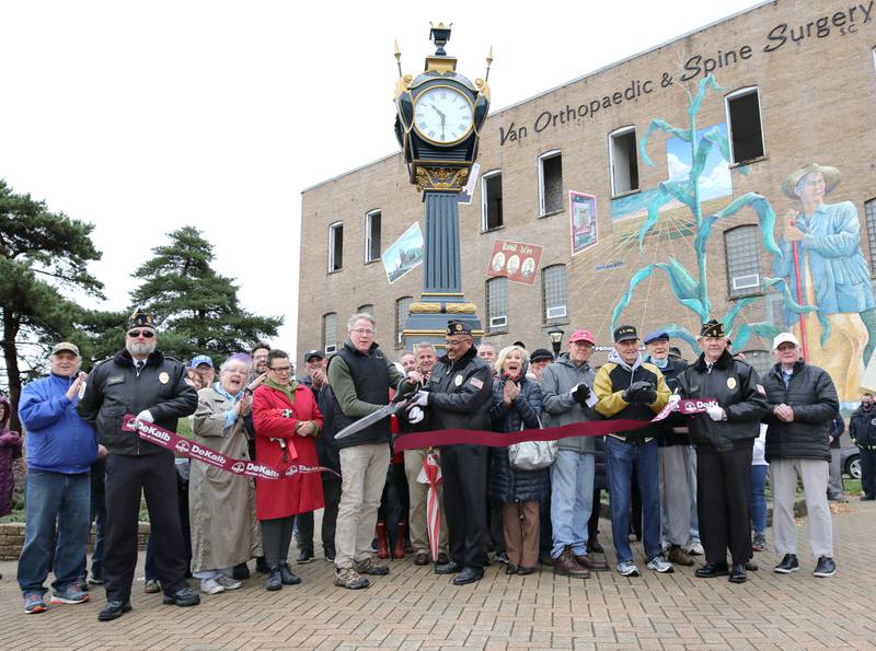 People cheer as Rotary President Brian Corr and Manny Olade, Commander of DeKalb American Legion Post 66, cut the ribbon on the newly renovated Soldiers' and Sailors' Memorial Clock Thursday, Nov. 11, 2021, during a Veterans Day ceremony at Memorial Park in downtown DeKalb.