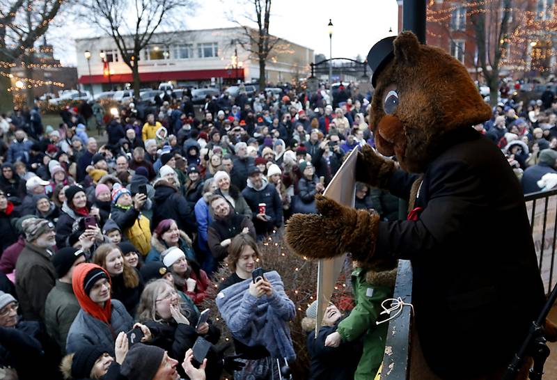 Woodstock Willie holds up an early spring sign to the crowd Friday, Feb. 2, 2024, during the annual Groundhog Day Prognostication on the Woodstock Square.