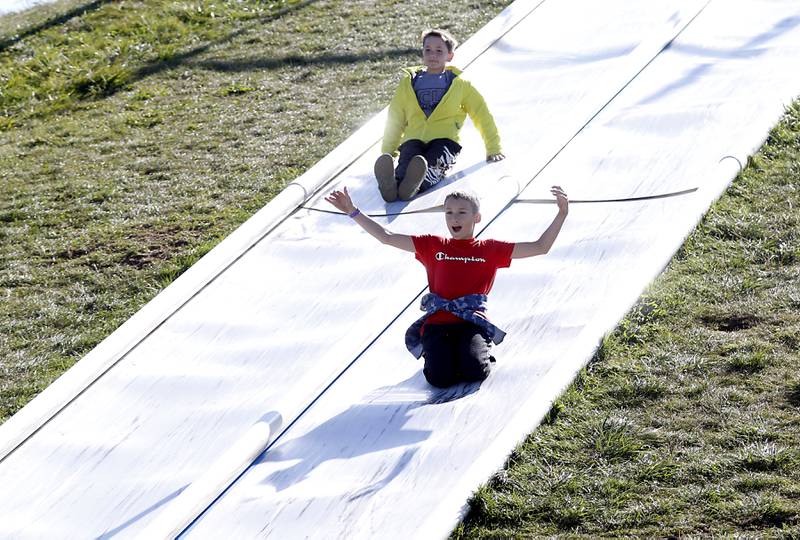 Aiden Kinchus, 12, and Logan Aarseth, 12, both of Crystal Lake, glide down a slide as they enjoy fall activities Monday, Oct. 10, 2022, at Richardson Adventure Farm, 909 English Prairie Road in Spring Grove. The farm's main attraction is a James Bond-themed corn maze, but it also features a 50-foot observation tower, train rides, a carousel, picnic areas, wagon rides, a zip line, 150- and 100-foot slides, zorbing, a petting zoo, pumpkin patch, goat feeding area, pedal kart tracks, live music on weekends, a kid's play area, jumping pillows, pig races, air cannons, a paintball shooting gallery, indoor restrooms, gift shop and wine tasting bar.