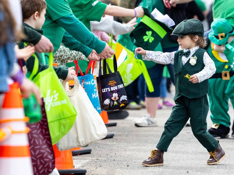 Will LaPage, walking with Abbot Tree Care Professionals, hands out candy during the St. Charles St. Patrick’s Parade on Main Street in St. Charles on Saturday, March 15, 2025.