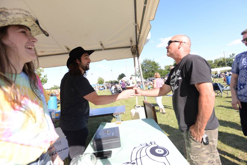 Harold Finnelly of La Grange gets beer from Milk Money venders Andrew Galletti and Maggie Buhle during the Country Jam held at Gordon Park in La Grange on Saturday, Aug. 10, 2024.