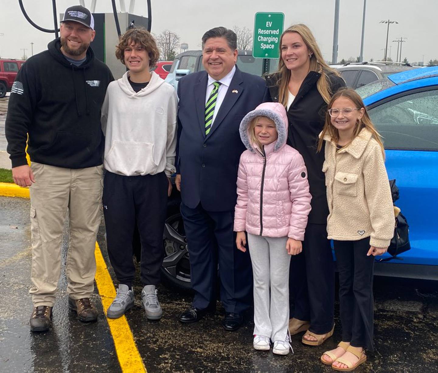 Ed West, owner of Joliet-based Veterans Energy Team, which facilitated the installation of the charging station, with his son, Anthony, Gov. Pritzker, daughter Aria, wife Cassie and daughter Autumn.