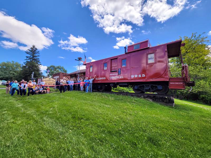 The Genoa Area Chamber of Commerce celebrating the Kishwaukee Valley Heritage Society Museum's caboose renovation with a ribbon-cutting
