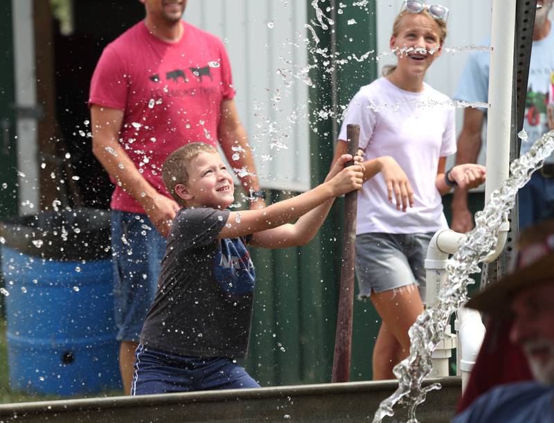 Bradley Ingram, 7, from Warrenville, works a hand powered water pump Thursday, Aug. 7, 2025, at the 68th annual Sycamore Steam Show and Threshing Bee at Taylor Marshall Farm on Lukens Road in Sycamore.