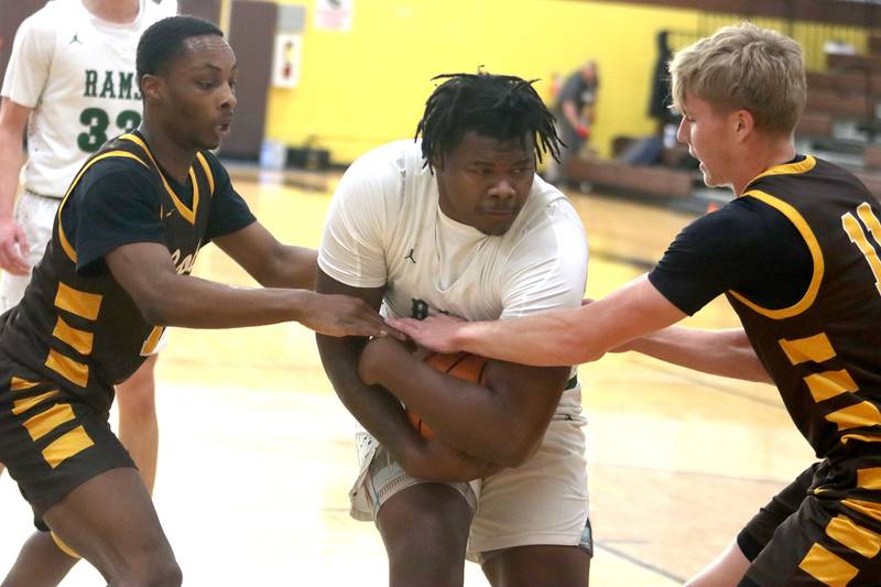 Jacobs’ Elijah Bell, left, and Carson Goehring, right, tussle with Grayslake Central’s Cordell Johnson under the net  in varsity boys basketball Hinkle Holiday Classic action on Tuesday, Dec. 23, 2025, at Jacobs High School in Algonquin.