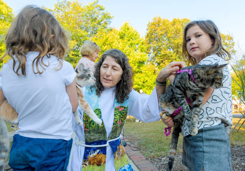 Pastor Trudy Stoffel from Geneva Lutheran Church blesses cats Isabella and Rosa as sisters Molly and Lydia Slicer hold them during the annual pet blessing service on Saturday, Oct 4, 2025 in Geneva.