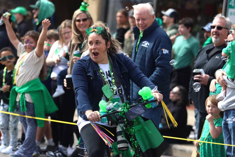 Photographer Kelsey Adams gathers cheers from the crowd as she cruises with the ShamROCKS the Fox Parade along Green Street through McHenry on Saturday, March 15, 2025.