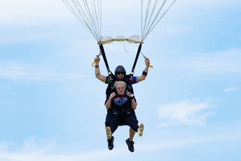 (front to back) Kathy Traegar is strapped to Chad Staerkel of Skydive Chicago as they look to land on Friday, July 11, 2025 at Skydive Chicago in Ottawa.