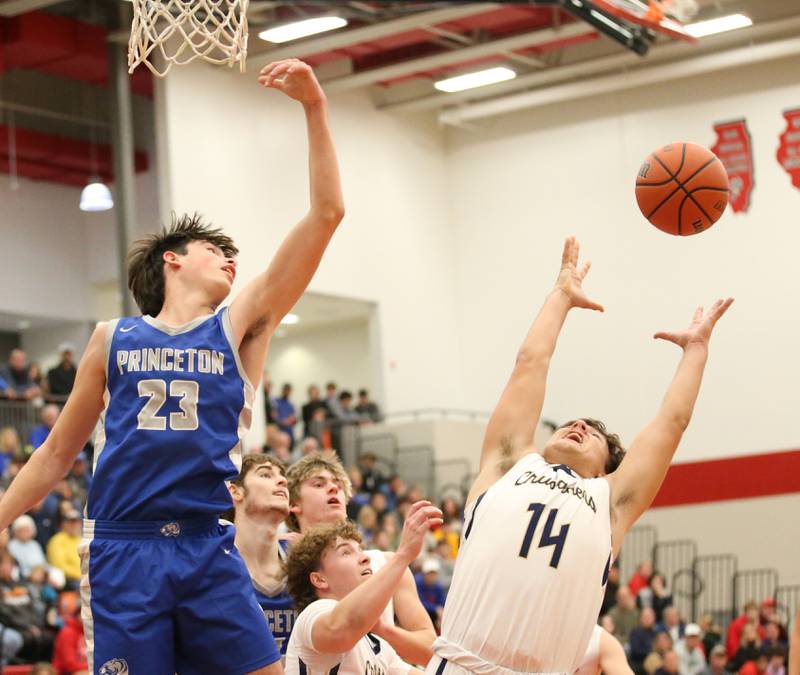 Marquette's Alex Graham (right) looks to haul in a rebound over Princeton's Noah Laporte (left) during the Colmone Classic tournament on Friday, Dec. 9, 2022 at Hall High School in Spring Valley.