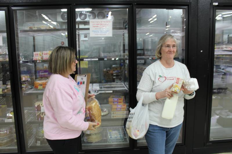 Crystal Lake Food Pantry volunteers Heather Marts and Joanna Bradshaw gather food for a client order.