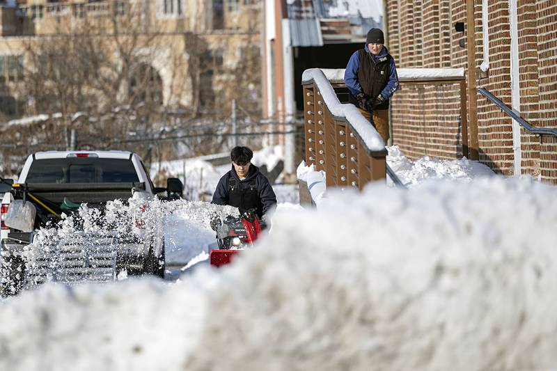 Isaac Kendrick (left) and Carson Leigh work to clear the sidewalk of Mad Water Saloon Sunday, Nov. 30, 2025, in Dixon.