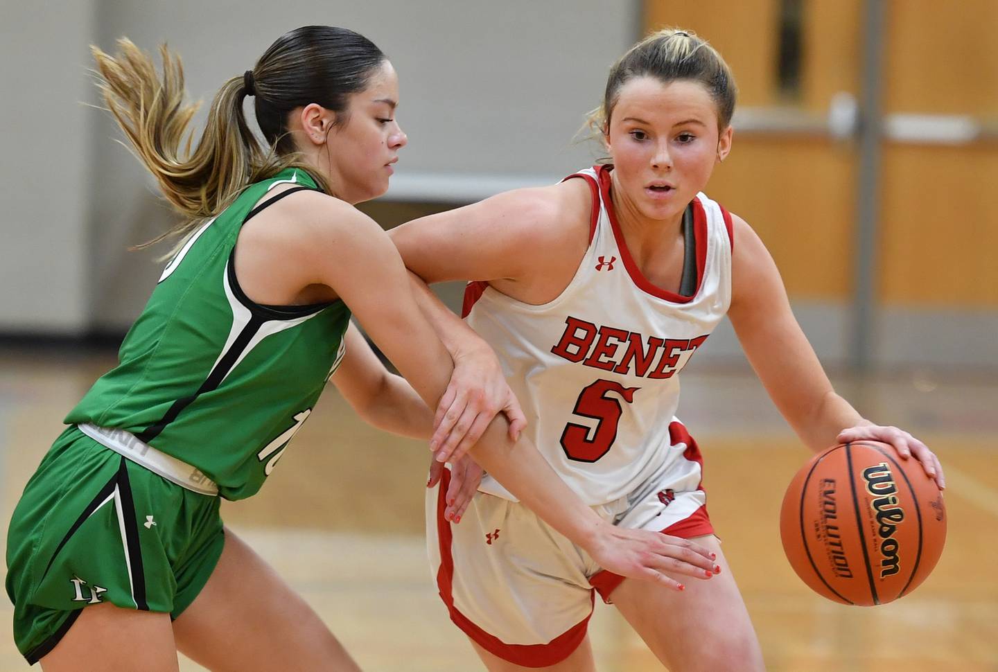 Benet’s Lenee Beaumont (5) drives past York's Lizzie Baldridge during a game on Dec. 20, 2022 at Benet Academy in Lisle.