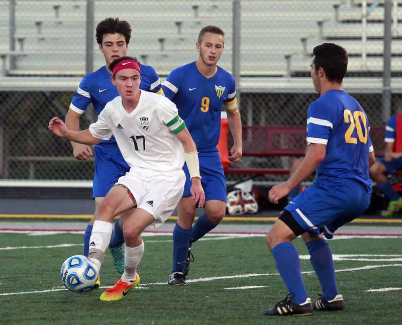 Grayslake Central's Trevor Veenstra takes control of the ball surrounded by Johnsburg defenders, Andrew Calhoun, Logan Andersen and Will Conroy, in the second half during the regional semi-final game at Antioch Community High School.