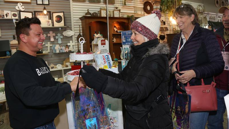 Nick Herrera of Floral Expressions (left) gives chocolates to Pam Cahill and Michelle & Ron Citta during the 8th Annual Chocolate Walk for Charity in Oswego on Saturday, Feb. 8, 2025.