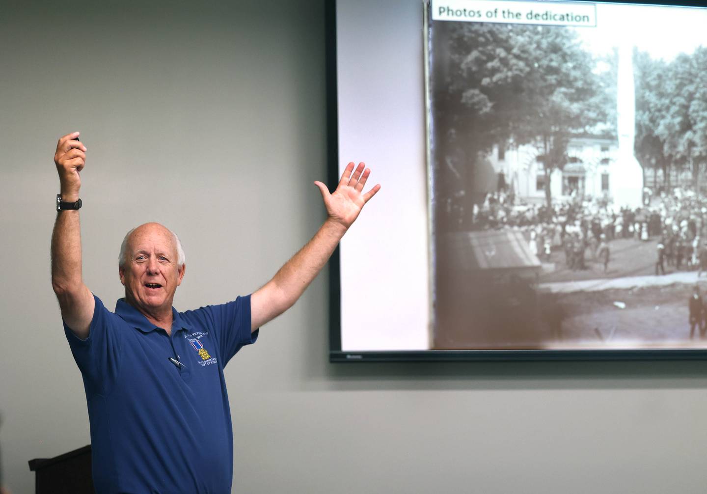 Dennis Maher, from the Sons of Union Veterans of the Civil War, talks about the dedication ceremony of the DeKalb County Soldiers and Sailors Monument in 1897, shown on the screen, Thursday, Sept 11, 2025, during his presentation “Courthouse Guards” at the DeKalb County History Cener in Sycamore. The Soldiers and Sailors monument stands in front of the DeKalb County Courthouse in Sycamore.