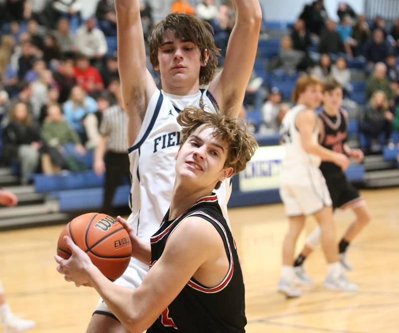 Woodland's Zander Radke looks to pass the ball while being guarded by Fieldcrest's Brady Ruestman on Tuesday, Dec. 19, 2023 at Fieldcrest High School.