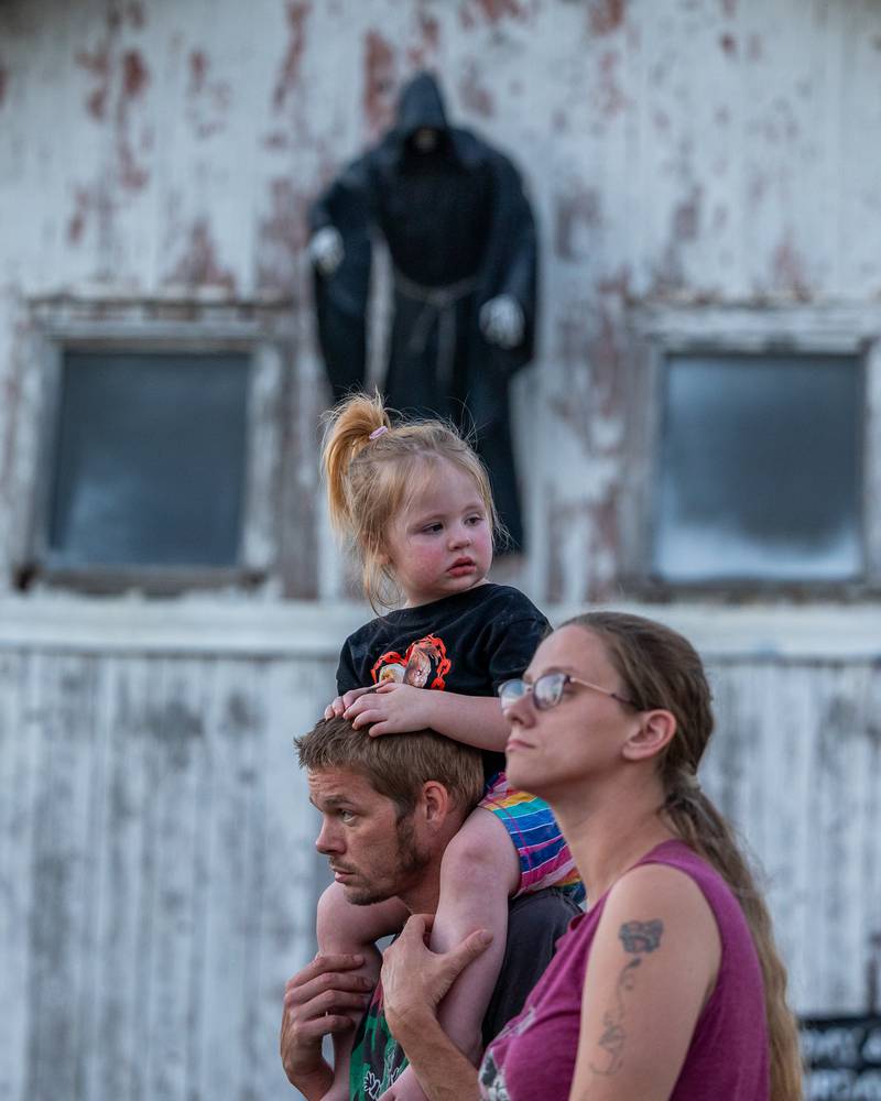(from left) Michael Behrens holds Zariah on shoulders next to Robin Fleming under halloween decoration at the Monster Mash Balloon Bash on Saturday, Oct. 4, 2025 at the Bureau County Fairgrounds in Princeton.