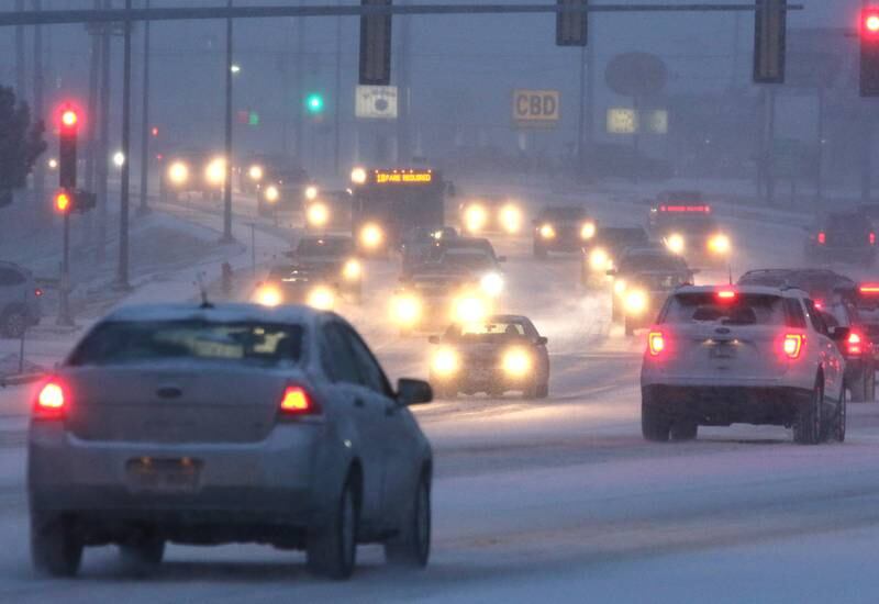Vehicles carefully make their way through the snow down Sycamore Road in DeKalb