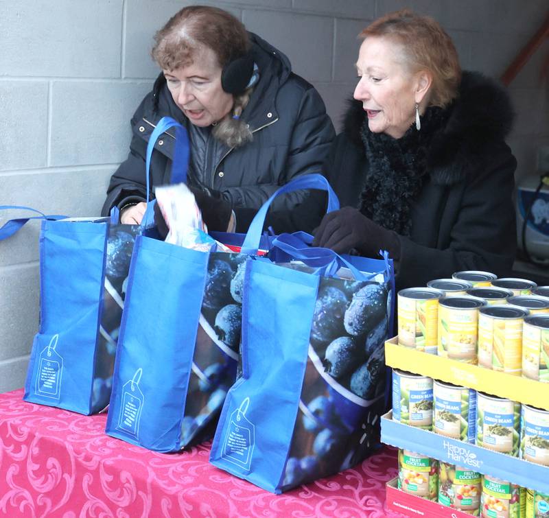 Stage Coach Players Outreach Committee members Deb Brubaker, (left) and Jan Kuntz sort donations and pack bags Tuesday, Nov. 15, 2022, while collecting donations at the theater in DeKalb for their Thanksgiving food drive. The group is working with the Salvation Army to put together Thanksgiving meals for local families in need.