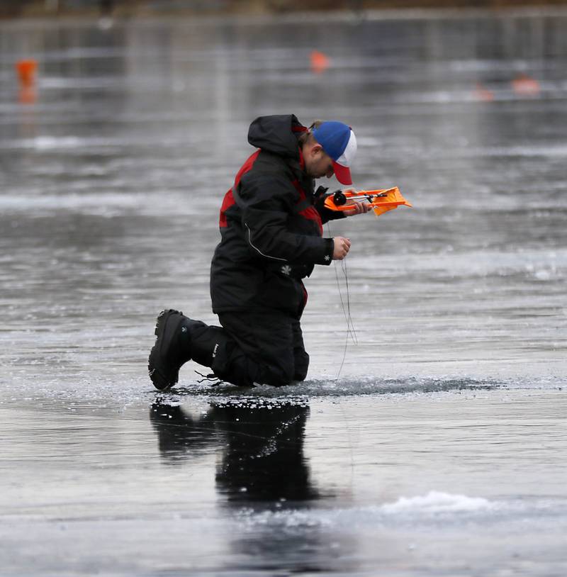 Dylan Kowalski sets up a tip-up while ice fishing on Wednesday, Jan. 8, 2025, on the westside of Crystal Lake near the Lakewood Village Hall.