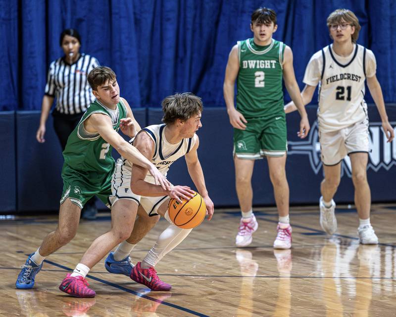 Braden Hahn (2) of Fieldcrest dribbles ball in lane whilst Hunter Paulson (25) of Dwight reaches to steal on Monday, December 15, 2025 at Fieldcrest High School in Minonk.