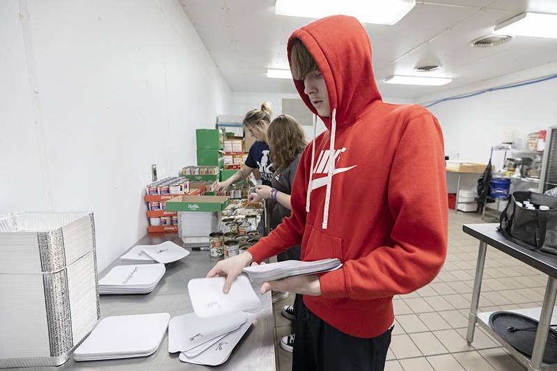 Sterling High School student Ethan Pearce organizes food containers Wednesday, Nov. 26, 2025, while volunteering as part of SVCC’s Impact program.