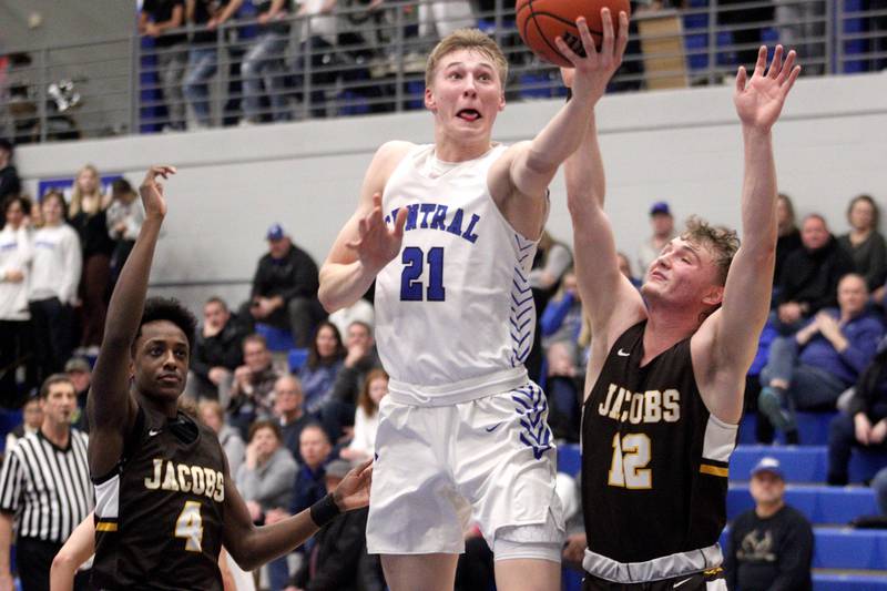 Burlington Central’s Drew Scharnowski soars past Jacobs’ Amari Owens (left) and Jackson Martucci in Fox Valley Conference play, Tuesday, Feb. 7, 2023, at Burlington Central.