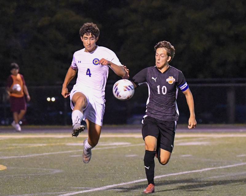 Wheaton North's Michael Shebar (4) kicks the ball away while being defended by Wheaton Warrenville South's Semin Razman (10) during the game on Thursday Sept. 11, 2025, held at Wheaton Warrenville South.