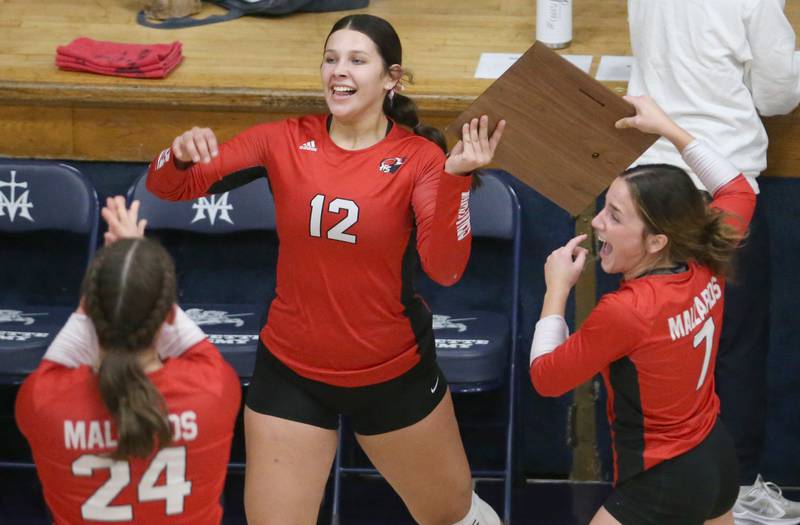 Henry-Senachwine volleyball players Kaitlyn Anderson and Lauren Harbison celebrate while hoisting the Tri-County Championship plaque after defeating Seneca on Thursday, Oct. 17, 2024 in Bader Gym at Marquette High School.