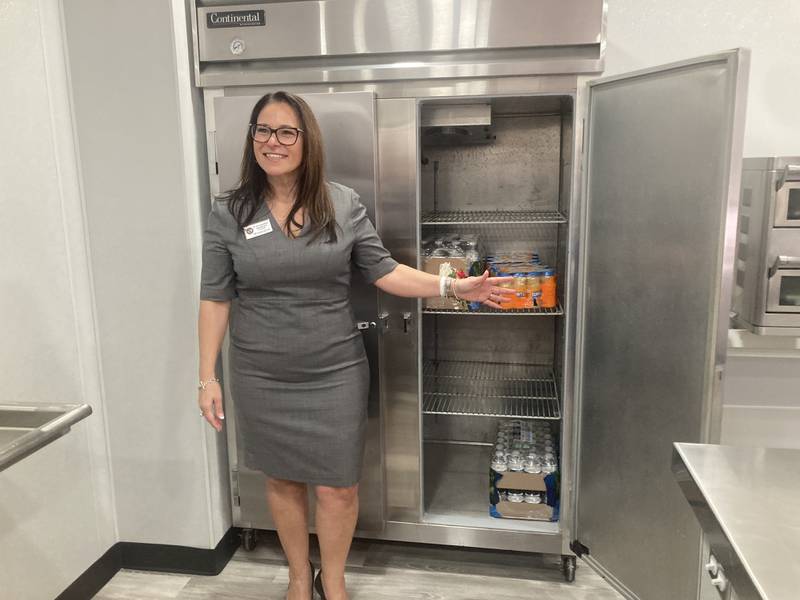 Dr. Lisa Caparelli-Ruff showcases the refrigerators in the new Lincoln School kitchen.