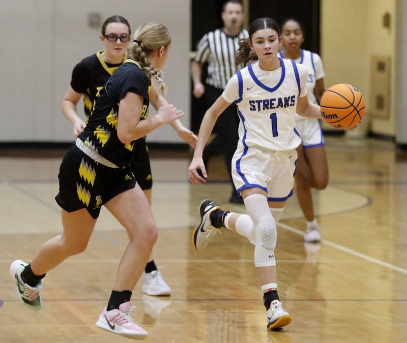 Woodstock's Alex Nowacki (right) brings the ball up the court against Harvard's Elena Olbrich during a Kishwaukee River Conference girls basketball game on Monday Jan. 12, 2026, at Woodstock High School.