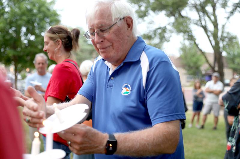 Robert Kieckhefer of Batavia lights his candle during a candlelight vigil Wednesday, July 6, 2022, at the Kane County Courthouse in Geneva. The vigil was called to join in solidarity in honor of the mass shooting at a Fourth of July parade in Highland Park.