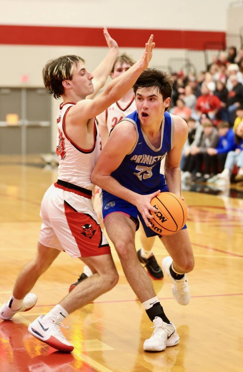 Princeton's Noah LaPorte drives on Hall's Braden Curran Friday night at Hall High School. The Red Devils won 62-54.