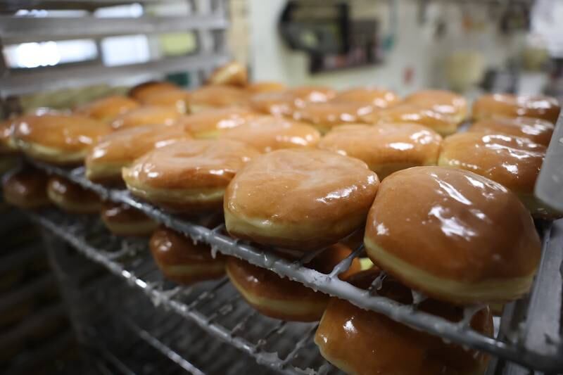 Donut Den prepares for their busiest day of the year as trays of paczki doughnuts in the kitchen. Monday, Feb. 28, 2022, in Joliet.