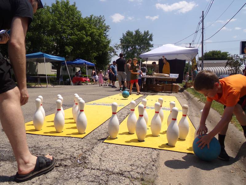 Children take turns street bowling Saturday, June 3, 2023, during the Summer Reading Kick-Off Party at Reddick Library in Ottawa.