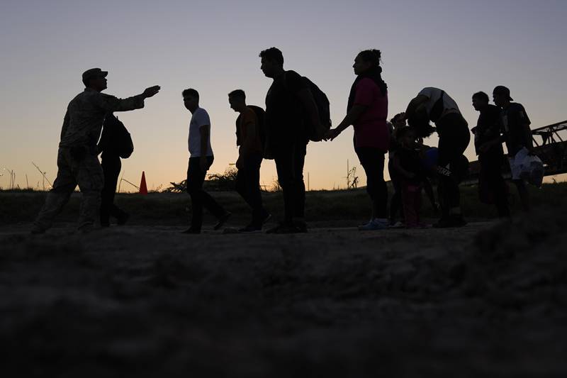 FILE - Migrants who crossed the Rio Grande and entered the U.S. from Mexico are lined up for processing by U.S. Customs and Border Protection, Sept. 23, 2023, in Eagle Pass, Texas.  U.S. authorities say border arrests during July have plummeted to a new low for Joe Biden’s presidency, raising prospects that a temporary ban on asylum may be lifted soon. The Border Patrol is expected to arrest migrants about 57,000 times during the month, down about 30% from June and the lowest tally since September 2020, when COVID-19 slowed movement across many borders. (AP Photo/Eric Gay, File)