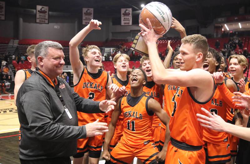 The DeKalb boys basketball team accepts the trophy after beating Sycamore in the First National Challenge Friday, Jan. 27, 2023, at The Convocation Center on the campus of Northern Illinois University in DeKalb.