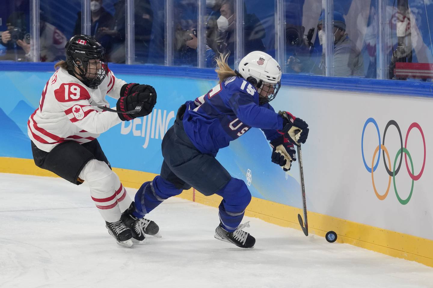 Canada's Brianne Jenner (19) chases United States' Savannah Harmon (15) during a preliminary round women's hockey game at the 2022 Winter Olympics, Tuesday, Feb. 8, 2022, in Beijing. (AP Photo/Petr David Josek)